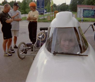 A youngster checks out the view from inside a Leitra. Heikki and Esko discuss Heikki's trike in the background